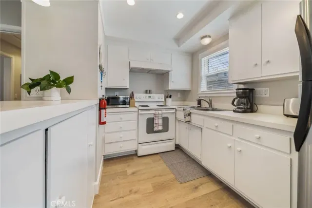 a kitchen with white cabinets stainless steel appliances and sink