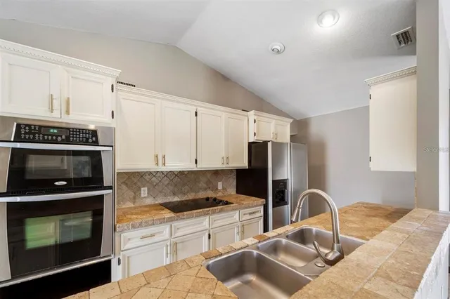 a kitchen with granite countertop a stove a sink and a microwave