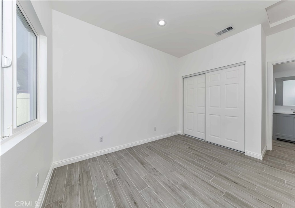 12615 George Street Garden Grove, CA 92840 - Photo 13 of 24 an empty room with wooden floor and windows