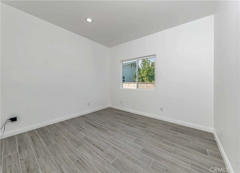 12615 George Street Garden Grove, CA 92840 - Photo 17 of 24 an empty room with wooden floor and windows