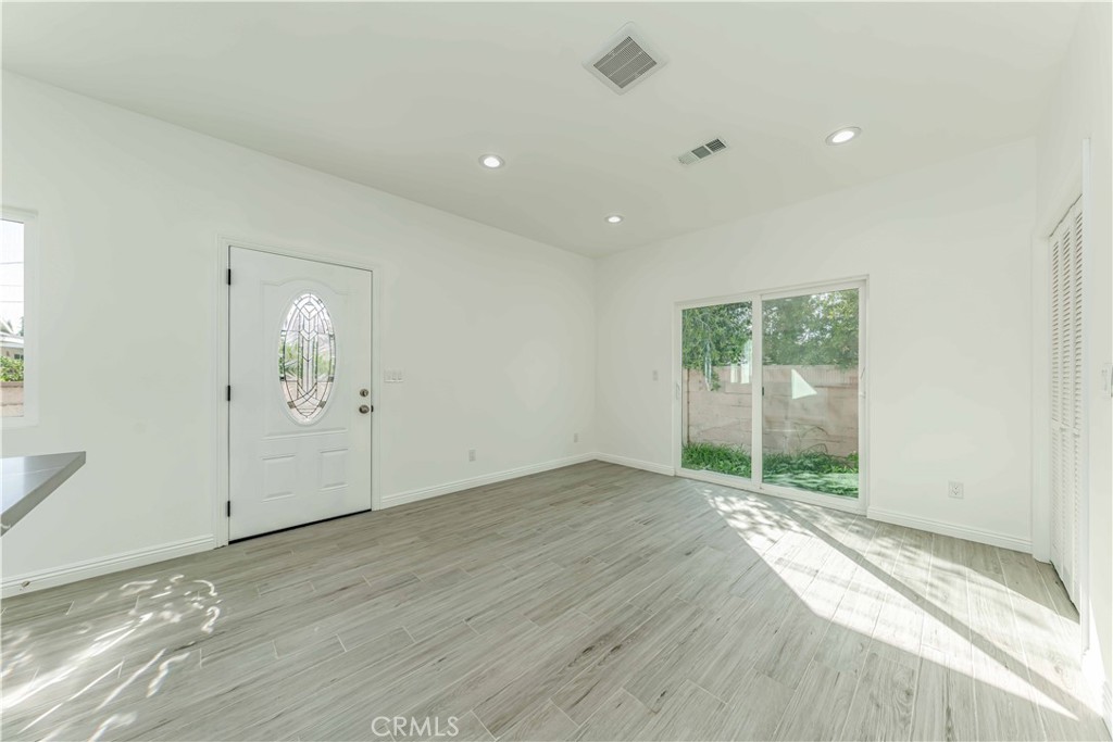 12615 George Street Garden Grove, CA 92840 - Photo 3 of 24 an empty room with wooden floor and windows