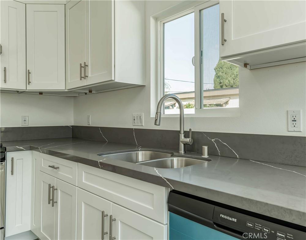 12615 George Street Garden Grove, CA 92840 - Photo 8 of 24 a kitchen with granite countertop white cabinets and a sink