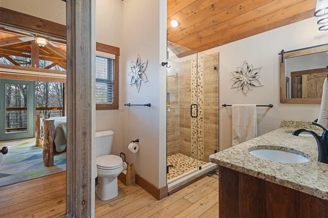 a backyard of a house with large trees and lawn chairs