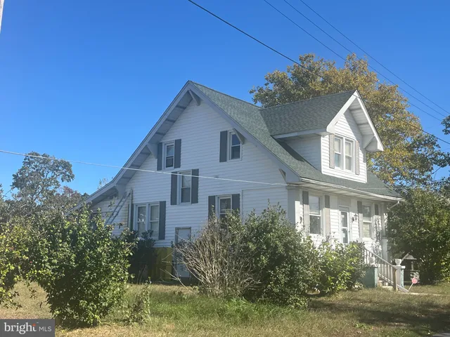 a view of a white house with a yard and potted plants