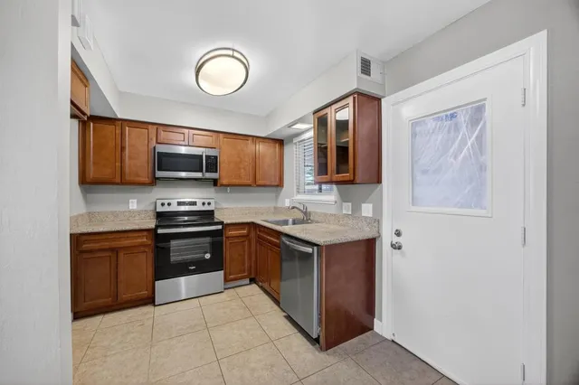 a kitchen with stainless steel appliances granite countertop a sink and a stove