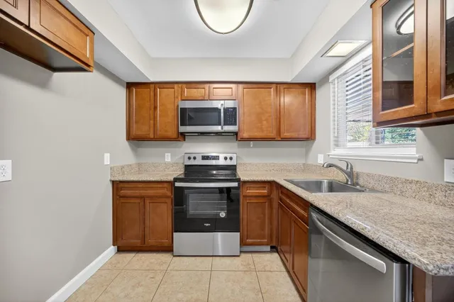 a kitchen with stainless steel appliances granite countertop a sink stove and cabinets
