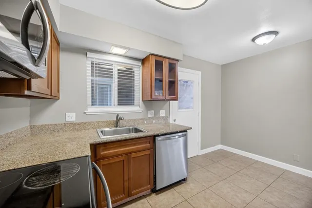 a kitchen with stainless steel appliances granite countertop a stove microwave and sink