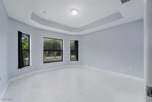 a view of an empty room with window and fire place