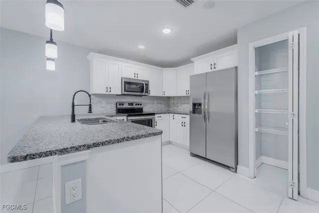 a kitchen with stainless steel appliances granite countertop a refrigerator a sink a stove a microwave and island