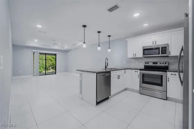 a kitchen with kitchen island granite countertop a stove cabinets and a refrigerator