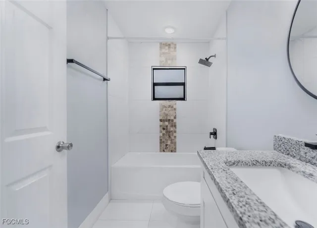 a bathroom with a granite countertop sink a toilet and shower