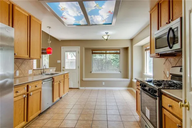 a kitchen with stainless steel appliances granite countertop a stove a sink and a microwave