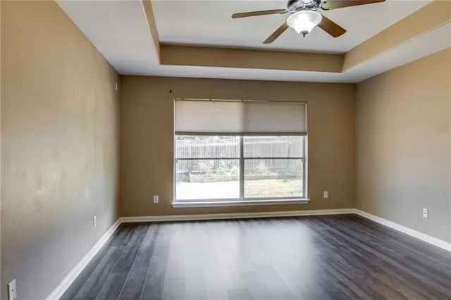 an empty room with a window and wooden floor