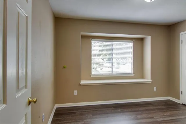 a view of a room with wooden floor and a window