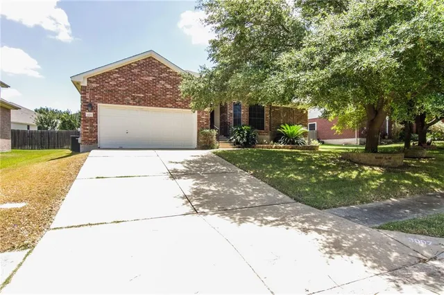 a front view of a house with a yard and trees