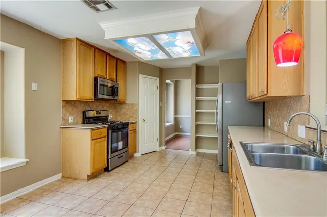 a kitchen with stainless steel appliances granite countertop a sink and a stove top oven