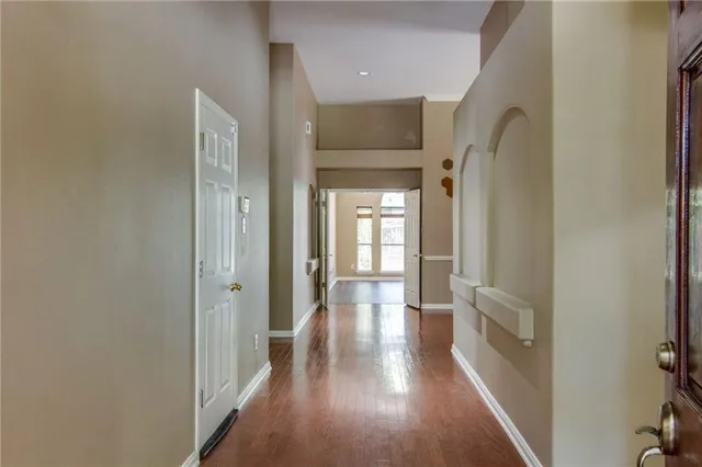 a view of a hallway with wooden floor and staircase