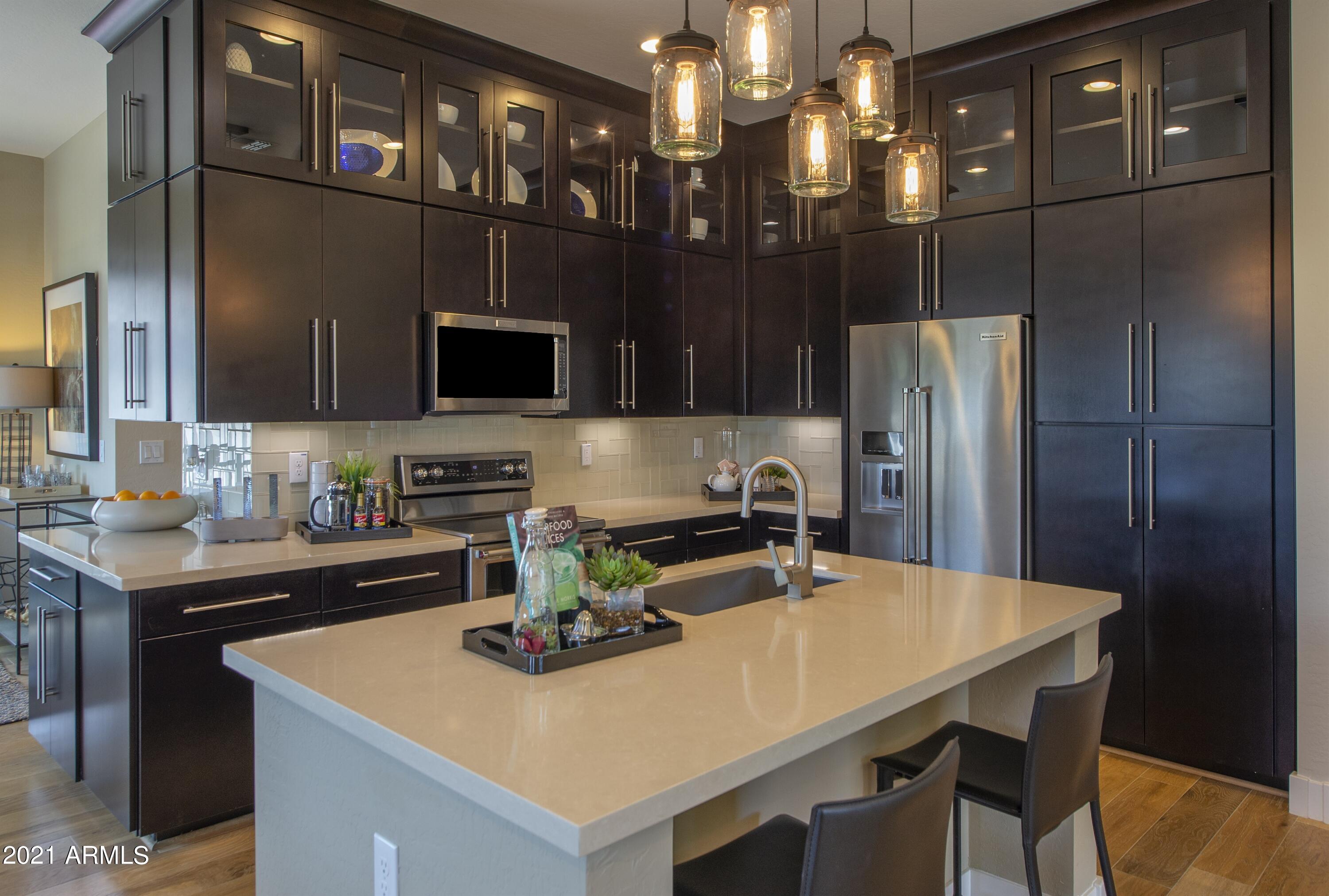6565 East Thomas Road, Unit 1042 Scottsdale, AZ 85251 - Photo 5 of 22 a kitchen with a sink a refrigerator and chairs