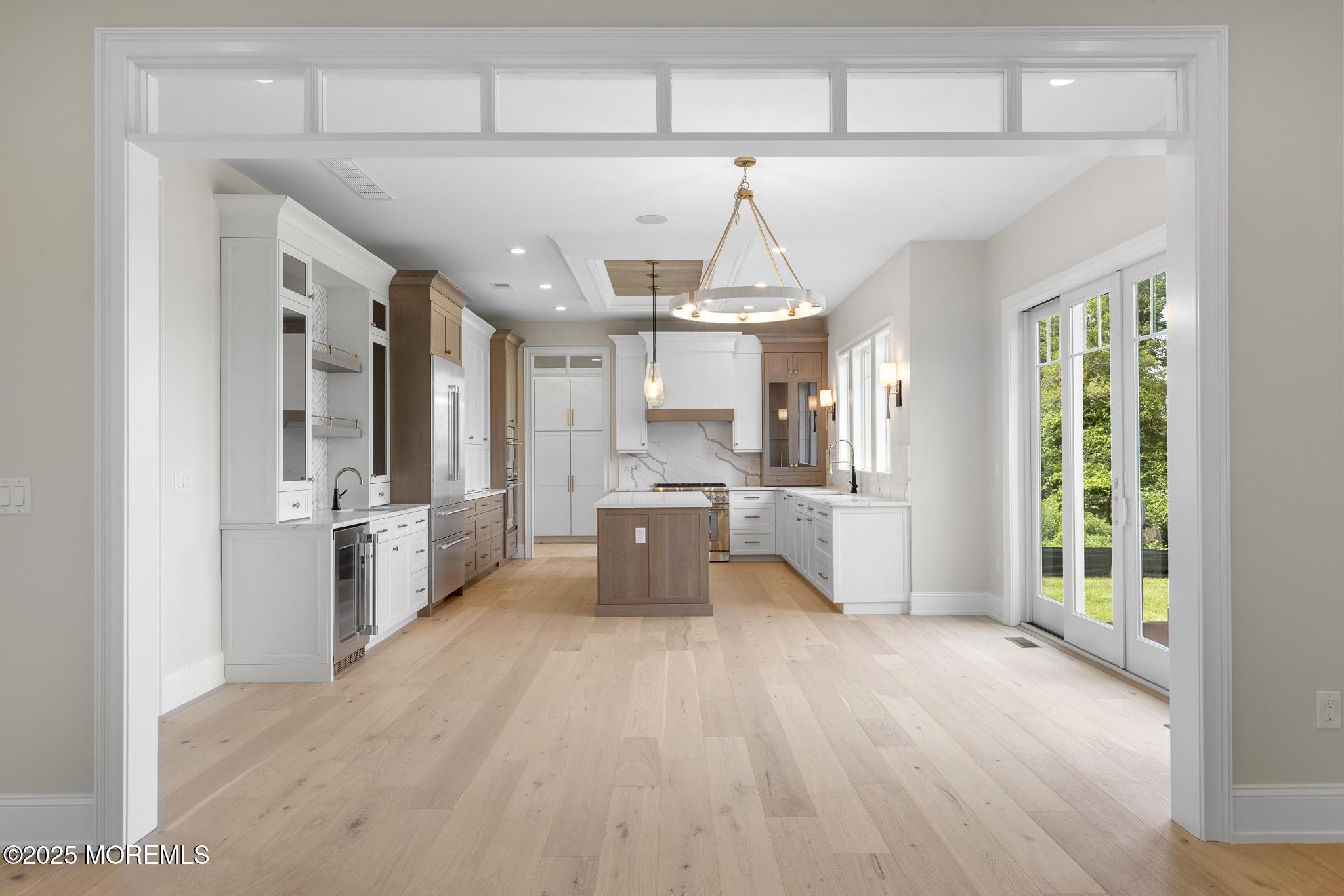 1604 Marconi Road Wall, NJ 07719 - Photo 68 of 69 a open kitchen with stainless steel appliances a refrigerator a sink dishwasher a oven with white cabinets and wooden floor