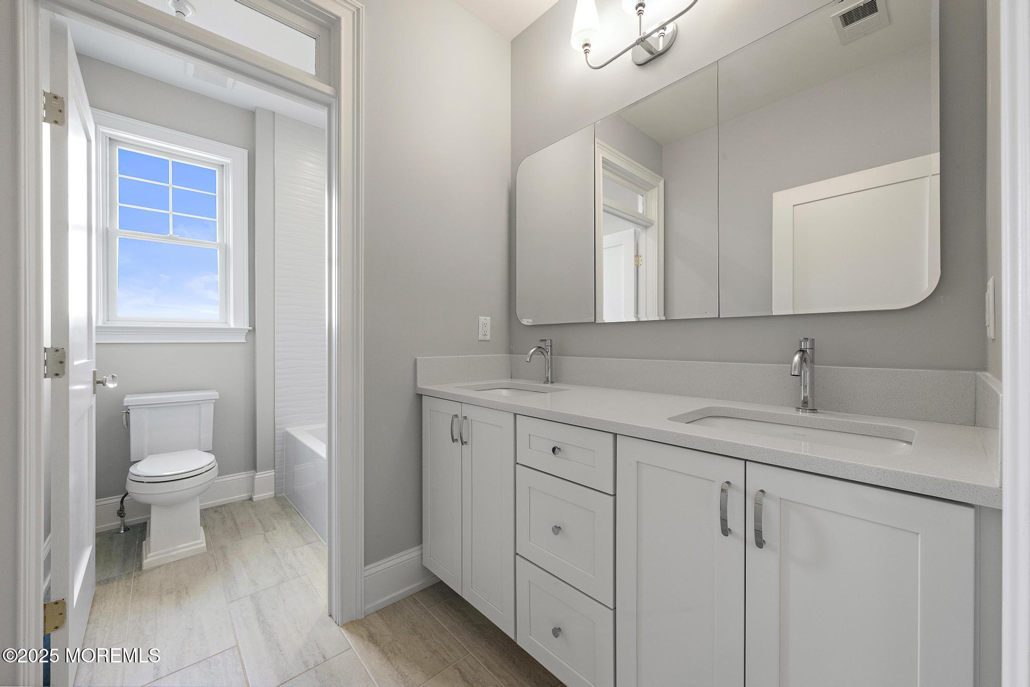 1604 Marconi Road Wall, NJ 07719 - Photo 53 of 69 a bathroom with a toilet a sink a vanity and mirror
