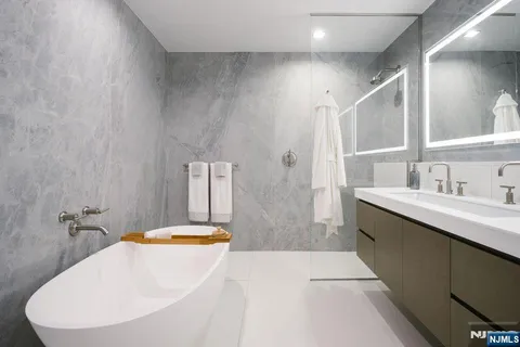 a bathroom with a tub sink and mirror