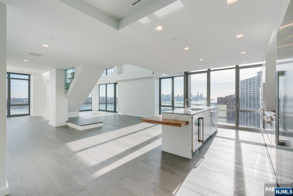 320 Adolphus Avenue, Unit 1415 Cliffside Park, NJ 07010 - Photo 14 of 35 a large white room with a large window and furniture