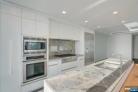 a kitchen with granite countertop cabinets stainless steel appliances and a counter space