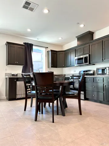 a kitchen with granite countertop wooden cabinets and a stove top oven