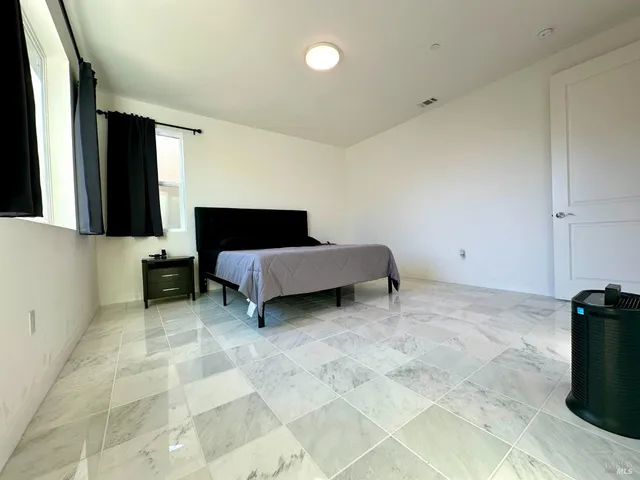 a bedroom with a bed and a window