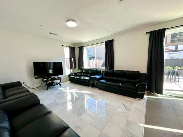 a living room with furniture and large windows