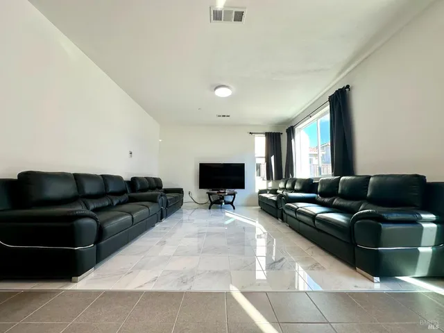 a kitchen with a refrigerator a stove a sink and chairs