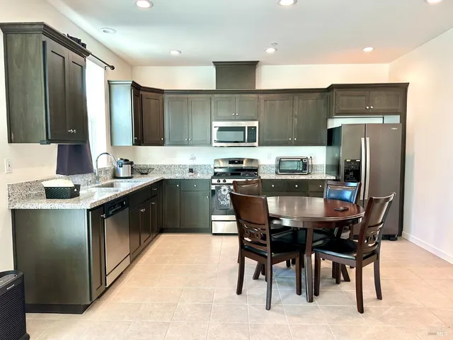 a kitchen with stainless steel appliances granite countertop a stove and a refrigerator
