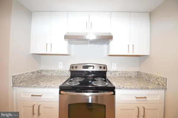 a stove top oven sitting inside of a kitchen