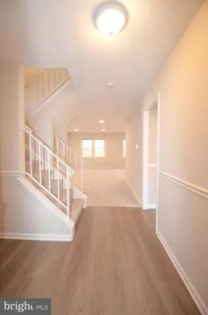 a view of a big room with wooden floor and windows