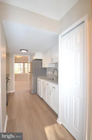 a kitchen with stainless steel appliances a refrigerator sink and white cabinets