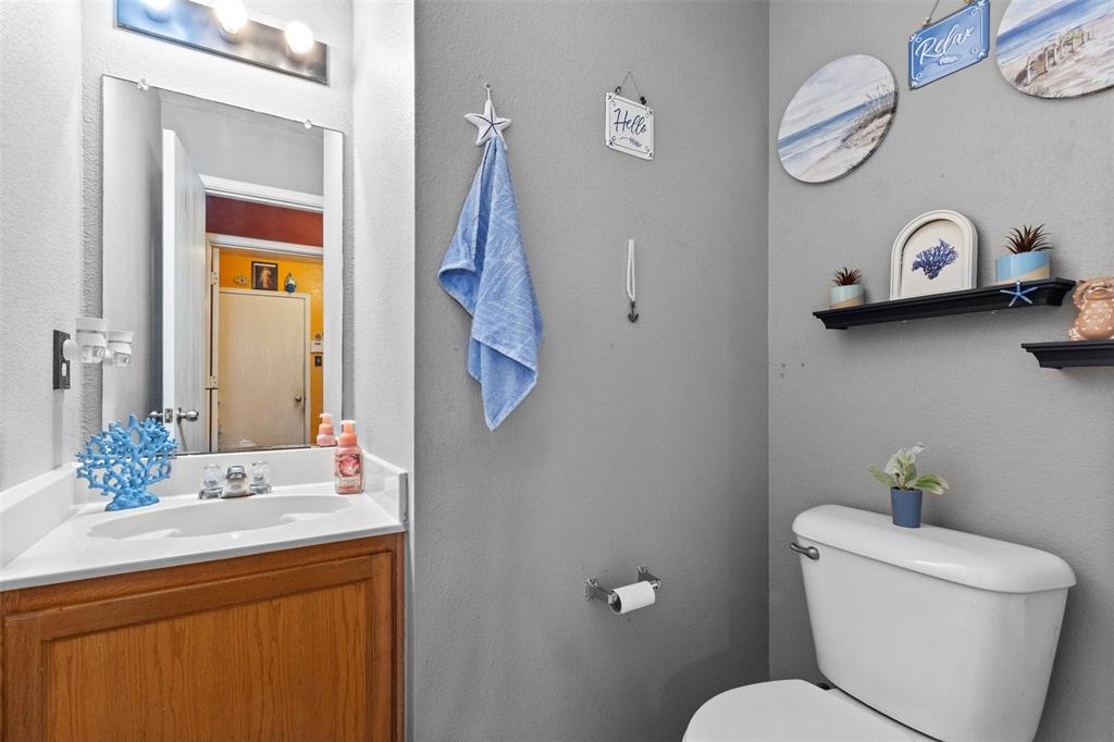 1034 Hollow Oak Road Lancaster, TX 75134 - Photo 11 of 29 a bathroom with a toilet a sink and a mirror