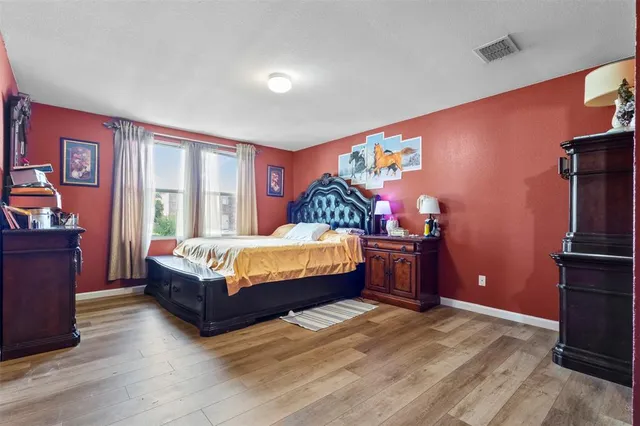 a bedroom with a bed and dresser with mirror