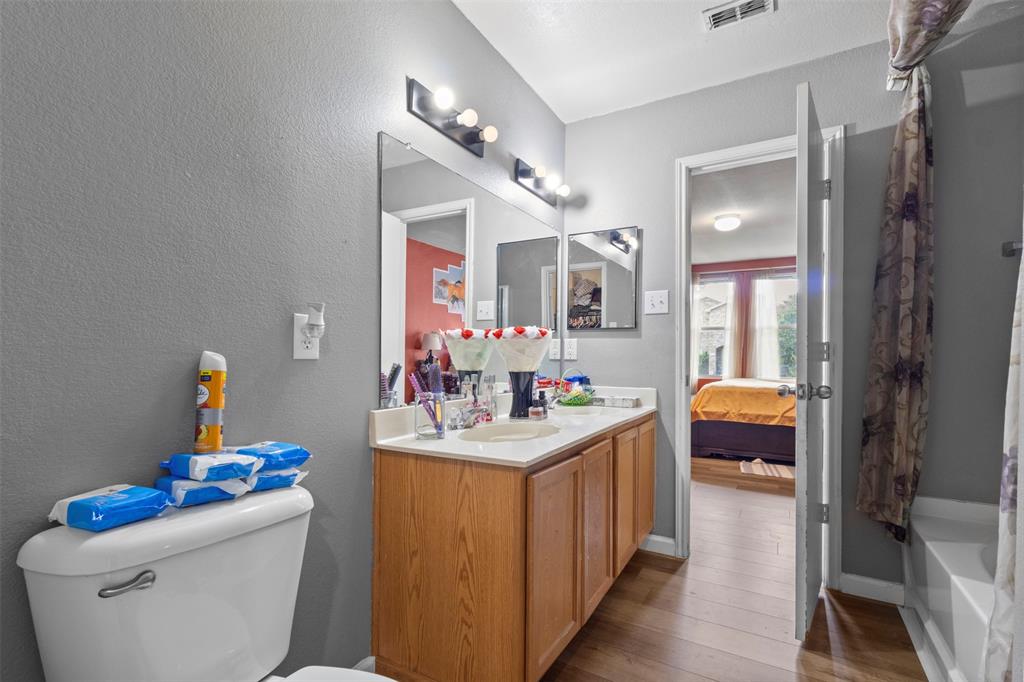 1034 Hollow Oak Road Lancaster, TX 75134 - Photo 16 of 29 a bathroom with a sink mirror vanity and toilet