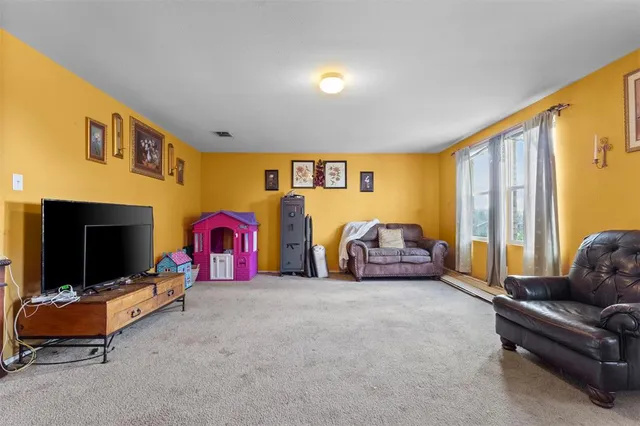 a living room with furniture a flat screen tv and a couch