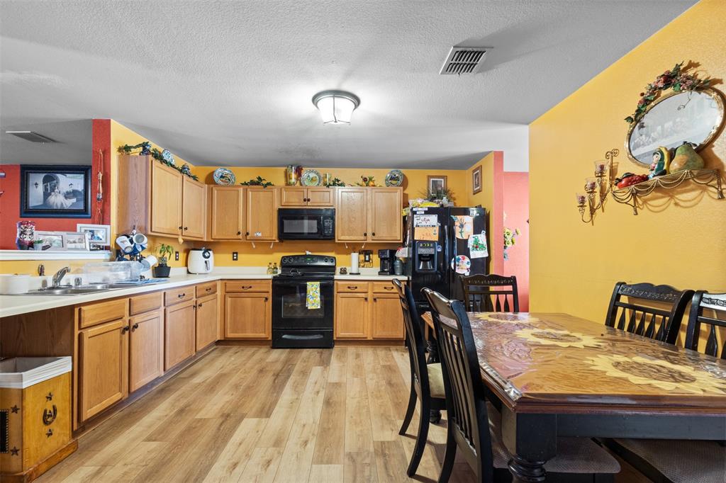 1034 Hollow Oak Road Lancaster, TX 75134 - Photo 8 of 29 a kitchen with a table chairs microwave and cabinets