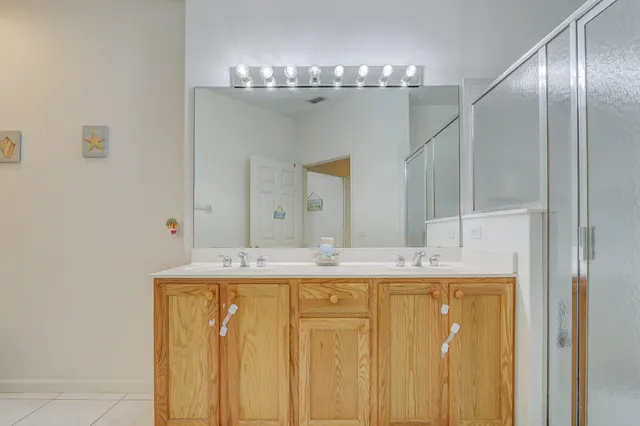 a bathroom with a granite countertop sink a mirror and a shower