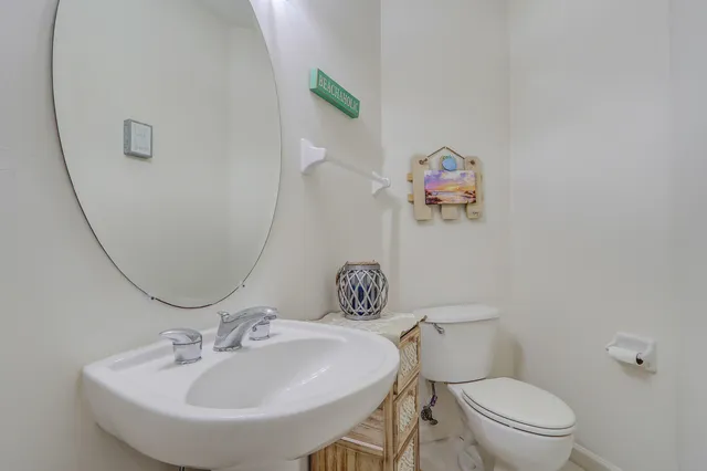 a bathroom with a sink mirror and toilet