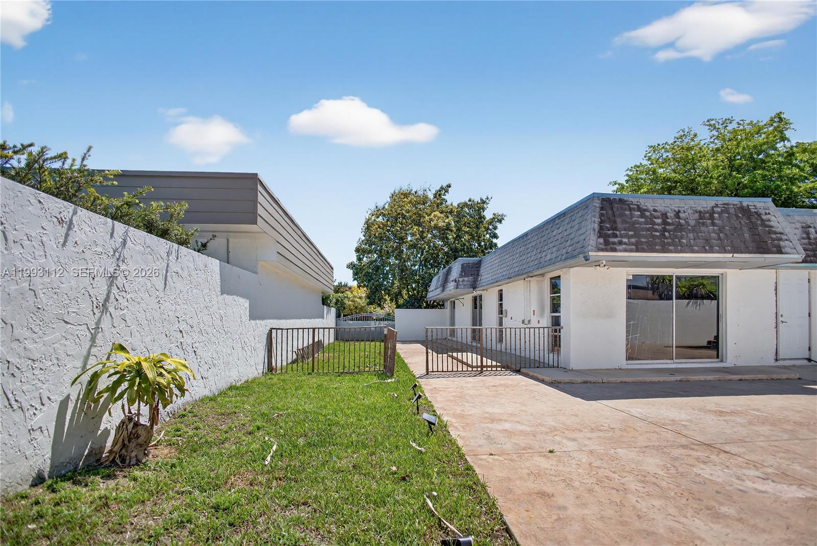 13471 Southwest 99th Terrace Miami, FL 33186 - Photo 7 of 44 a front view of a house with a yard and potted plants