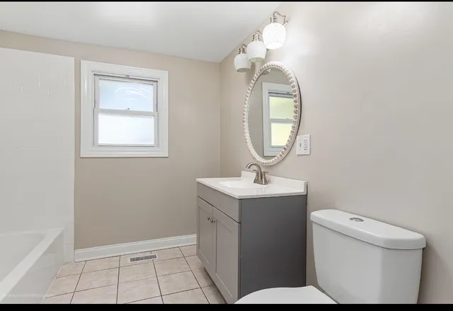 a bathroom with a toilet sink and mirror