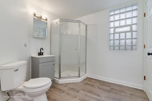 a bathroom with a toilet a sink and shower