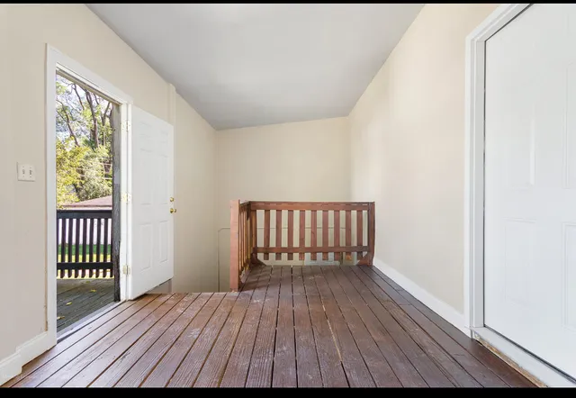a view of a room with wooden floor and a window