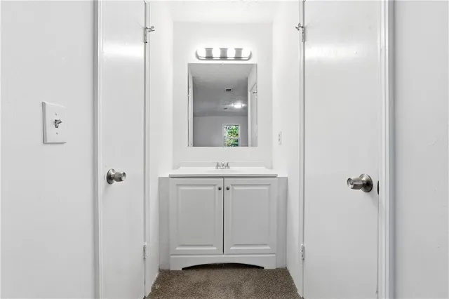 a bathroom with a sink a light fixture and a mirror
