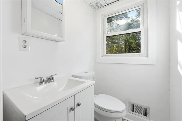 a bathroom with a sink a toilet and a window
