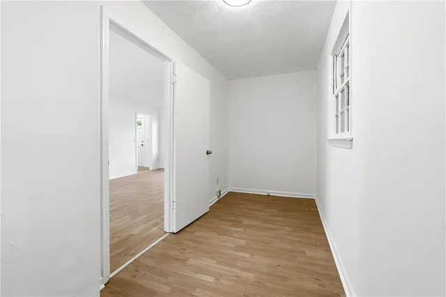 an empty room with wooden floor and mirror