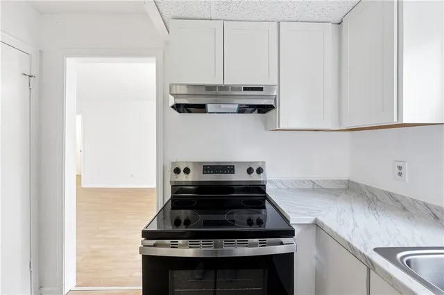 a stove top oven sitting inside of a kitchen